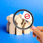 A magnifying glass looks at an angry mob of people with a poster. Social discontent and tension, protest, disagreement. join the protest movement. activism movement. public attention. Labor unions